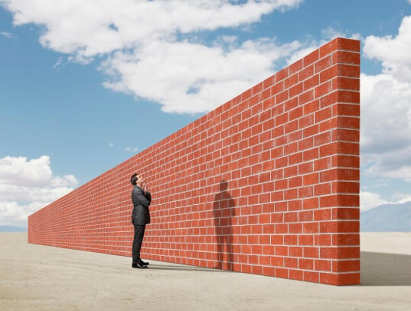 Mann vor Mauer und will drüber